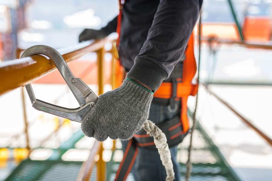 I dipendenti in cantiere trasportano beni di sicurezza e rispettano le linee guida di sicurezza / conformità in cantiere.